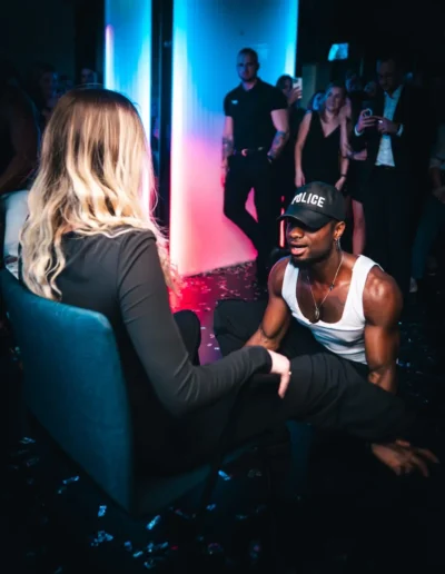 Gogo danseur en casquette de police animant une soirée face à une invitée assise