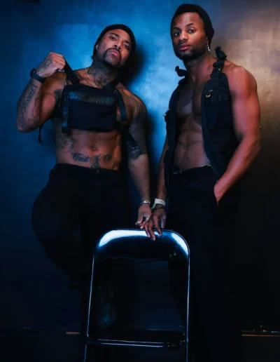 Deux gogo danseurs en harnais de cuir en studio, éclairage bleu