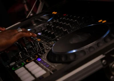 Mains d'un DJ réglant les curseurs d'un contrôleur lors d'une soirée