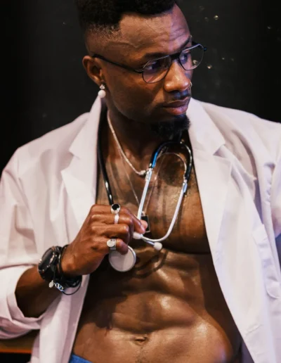 Gogo danseur en costume de médecin, blouse blanche et stéthoscope, sur scène