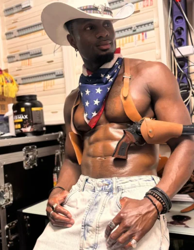 Gogo danseur en costume de cowboy, chapeau, bandana aux couleurs américaines et holster