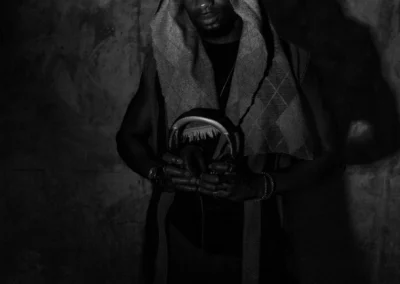 Portrait en noir et blanc d'un DJ tenant son casque devant ses platines