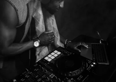 DJ en noir et blanc mixant sur un contrôleur Pioneer, ordinateur portable à côté